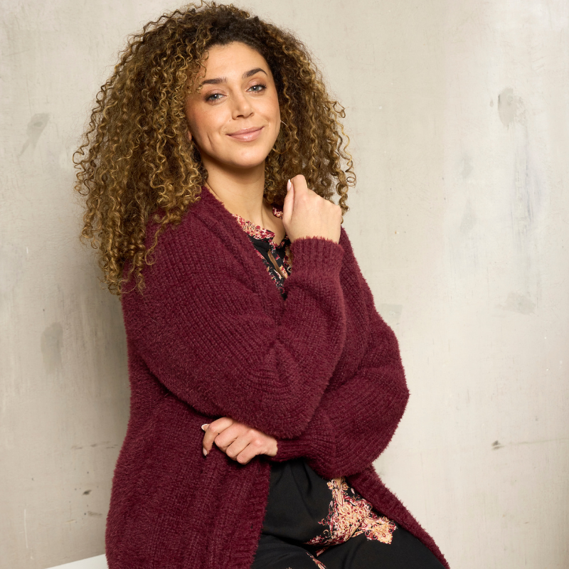 Woman in a black blouse and a black and white cardigan